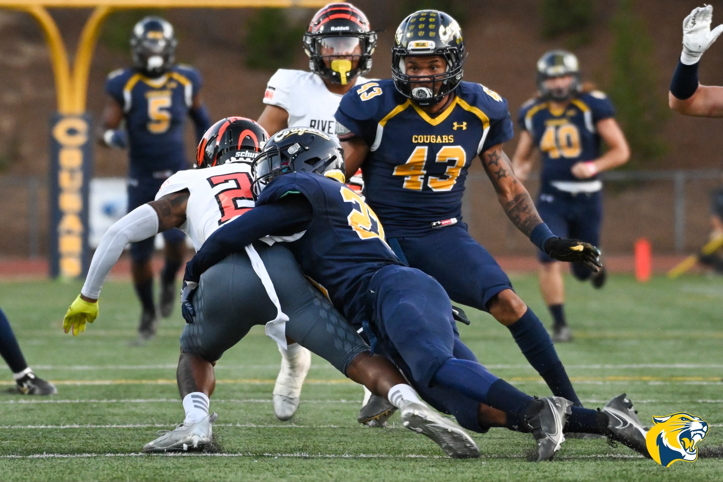 College of the Canyons defensive back Joshua Christopher (27) wraps of the Riverside City College ball carrier as teammate Jeremiah Cox (43) readies to pounce during the the No. 4 Cougars' 41-24 victory over No. 7 Riverside City College on Saturday. ?Dylan Stewart/1550 Sports