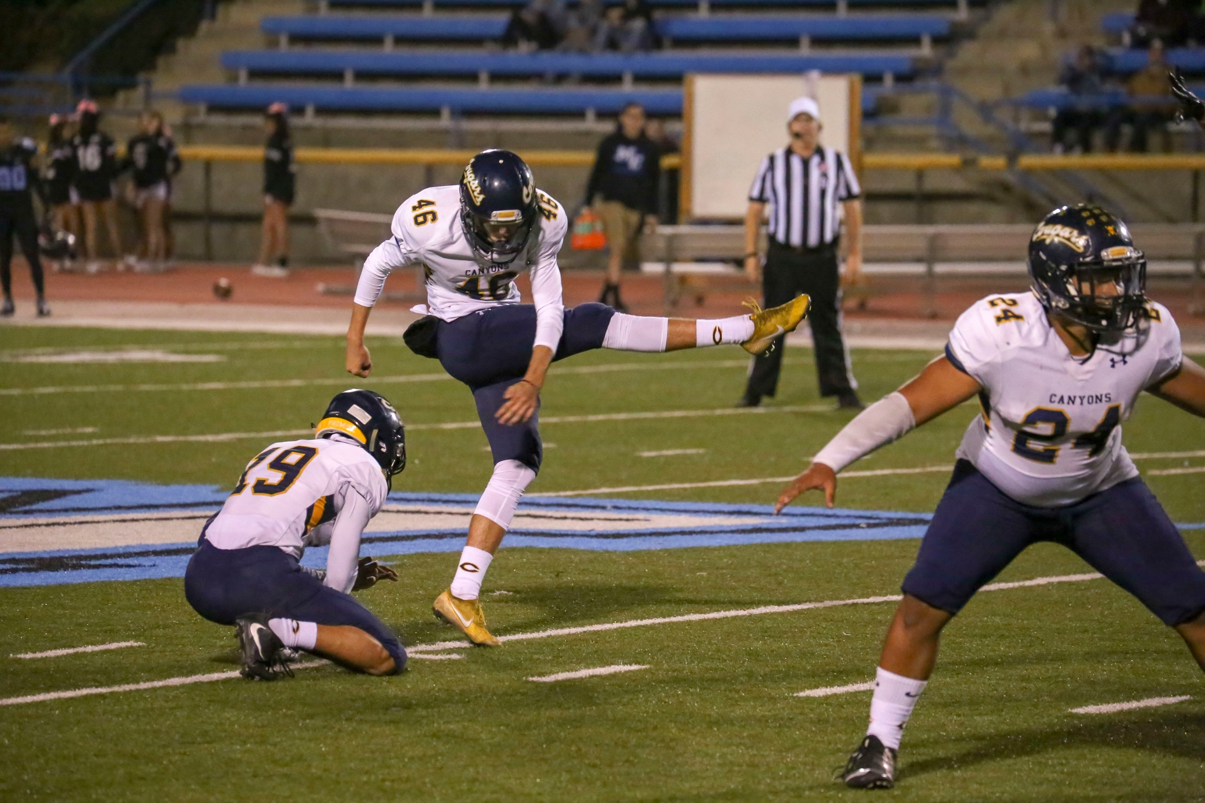 Stock image of College of the Canyons football student-athlete Tanner Brown kicking a football.