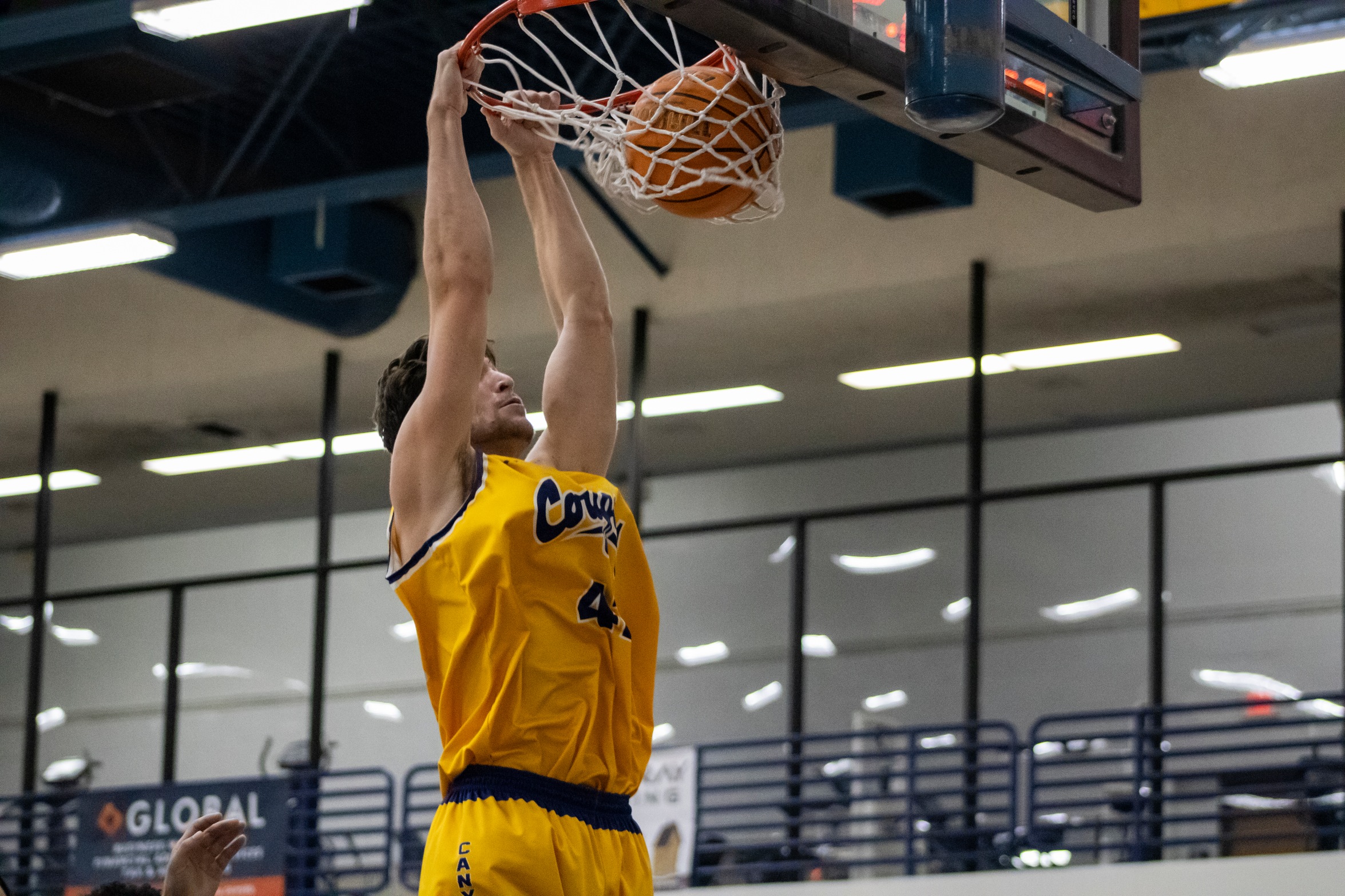 College of the Canyons men's basketball stock action photo of student-athlete Jonah El-Farra slam dunking a basketball.