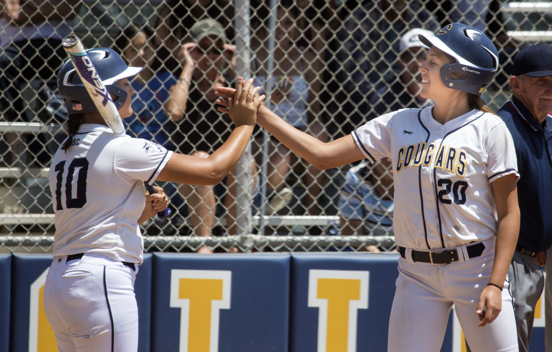 College of the Canyons sophomore Micayla Aguilar (20) is congratulated by teammate Camryn Webb (10) after breaking up Fullerton pitcher Jessica Lopez' no-hitter in the fifth inning of Saturday's elimination game. Jim McCormack/Fullerton College Athletics.