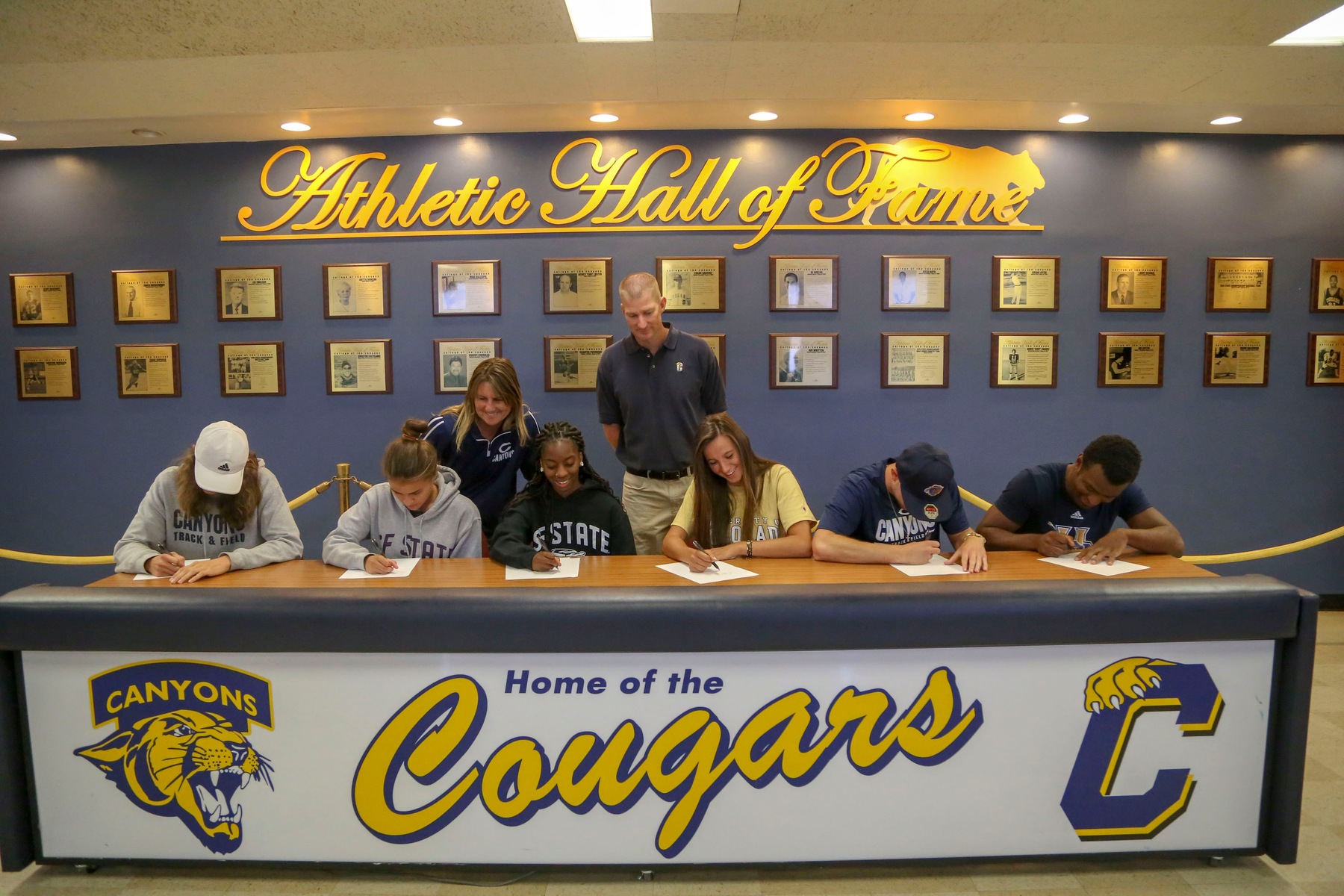 (From left to right) College of the Canyons track & field student-athletes Marcel Sylvester, Stephanie Martinez, Díani Ellis, Sophia Stephan, Slade Cavallaro and Leo Lambert take part in a signing day ceremony as COC track & field head coach Lindie Kane and associate athletic director Chad Peters look on. Jesse Muñoz/COC Sports Information Director