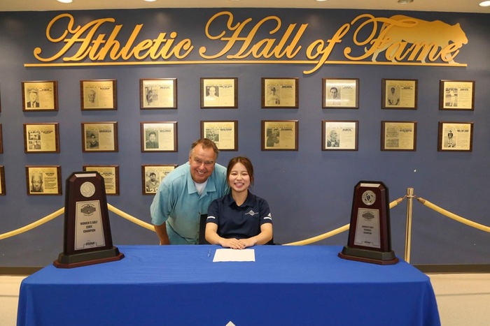 COC sophomore golfer Haruka Koda signs her National Letter of Intent with CSU, Fullerton as head coach Gary Peterson looks on.