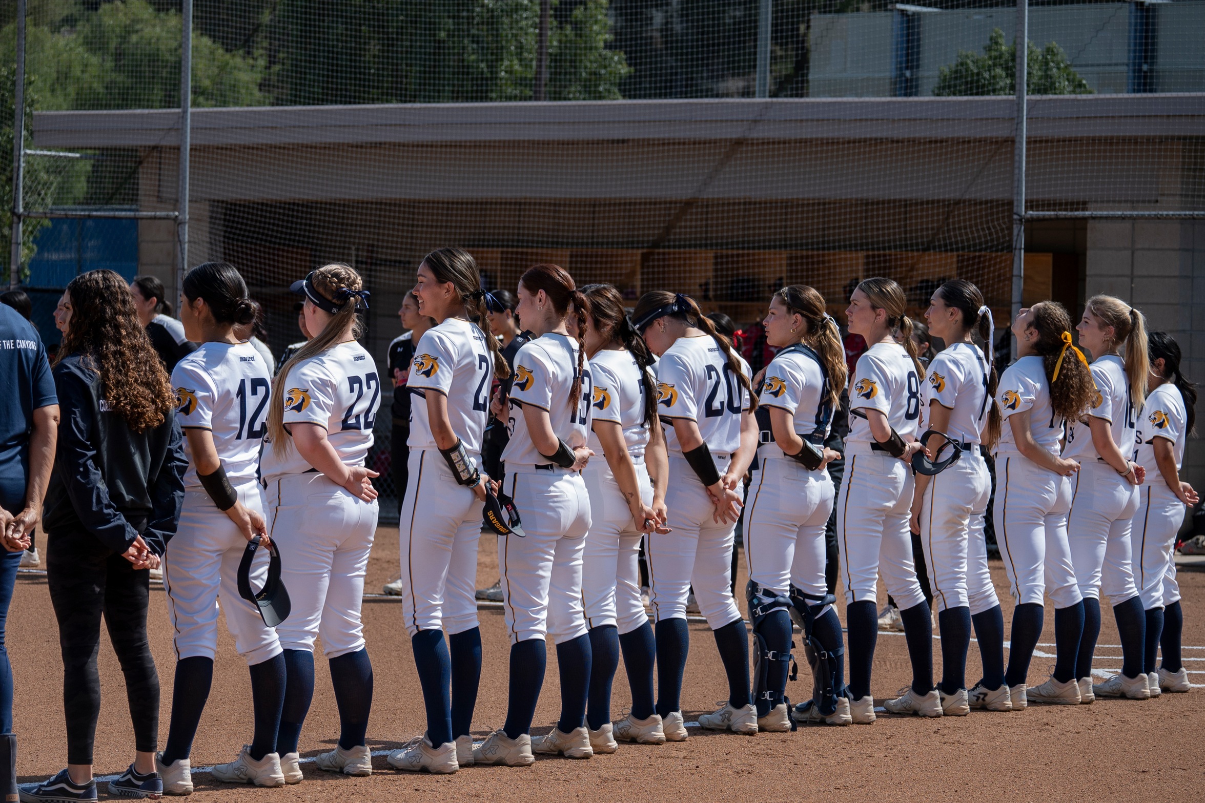 Stock image of COC softball team lined up on field prior to National Anthem.